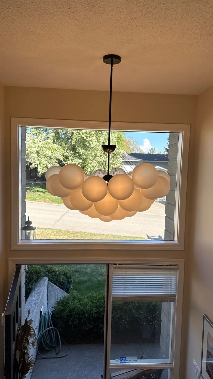Decorative residential pendant light installed above a stair landing.